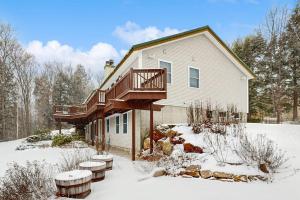 a house with a deck in the snow at Middle Ledge Lodge in Glen