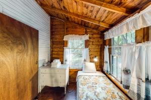 a bedroom in a log cabin with a bed and a window at Garden Island's Cedar in Charlotte