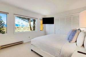 a white bedroom with a large bed and a window at Glacier D in Jackson
