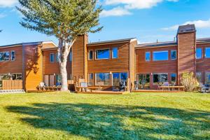 a large wooden house with a tree in the yard at Glacier D in Jackson