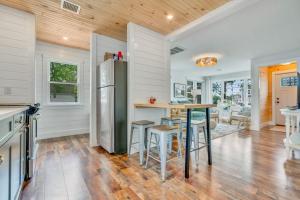 a kitchen with a refrigerator and a table with stools at Salt & Petal in Old Orchard Beach