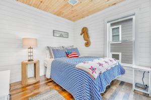 a bedroom with a bed with a blue and white comforter at Salt & Petal in Old Orchard Beach +35 photos