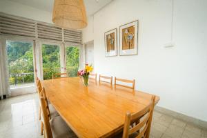 a dining room table with a vase of flowers on it at Wisma Nirwana Tretes near Cimory Prigen in Prigen
