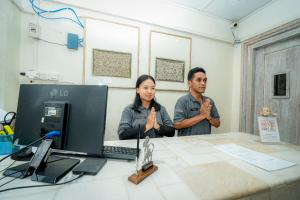 a man and woman sitting at a desk with a computer at Wisma Nirwana Tretes near Cimory Prigen in Prigen +45 photos