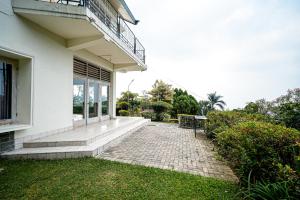 a white house with a bench on the side of it at Wisma Nirwana Tretes near Cimory Prigen in Prigen