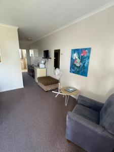 a living room with a couch and a table at Tower Court Motel in Hervey Bay
