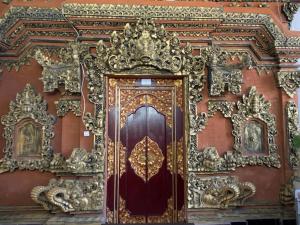 a golden door on the side of a building at Kabera House 1 in Ubud