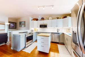 a kitchen with white cabinets and stainless steel appliances at Crown Mountain Retreat in Carbondale