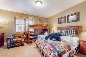 a bedroom with a bed with a teddy bear on it at Evergreen Retreat, Unit 101 in Avon