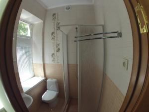 baño con ducha y aseo y ventana en Bike Hostel Dnepr, en Dnipro