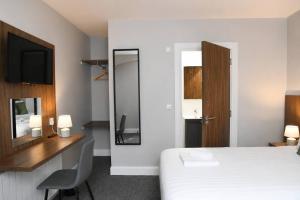 a hotel room with a bed and a television at Coach House Accommodation - Room 2 in Carrick on Shannon