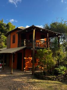 an orange house with a balcony on top of it at Chalé Retiro Real in Ouro Preto