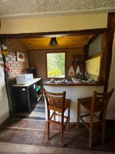 a kitchen with two chairs and a table and a counter at Chalé Retiro Real in Ouro Preto