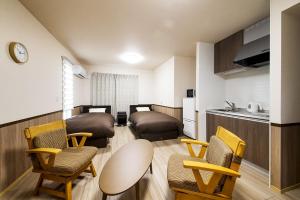 a room with two beds and chairs and a kitchen at 萩別邸 シーサイド1 HAGI Bettei SEASIDE1 in Hagi