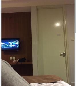 a room with a bed and a tv and a door at villa house luxury in Cianjur
