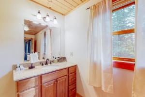 a bathroom with a sink and a mirror and a window at Pinecone Lodge in Newry +69 photos