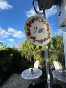 a sign for a studio hanging from a table at Pōhutukawa Studio in Tauranga