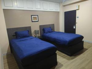 two beds in a room with blue pillows at Metro Residence in Surin +75 photos