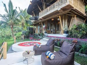 a house with two couches and a table in front of it at Uma Bali-Bamboo House in Selat