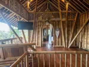 a large wooden building with a hallway and a doorway at Uma Bali-Bamboo House in Selat