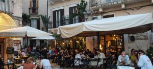 a group of people sitting at tables in an outdoor restaurant at Apulia Time in Bari