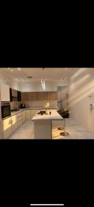 a large kitchen with a sink and a counter at Over lock in Buraydah +5 photos