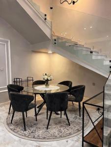 a dining room with a table and chairs and stairs at Over lock in Buraydah