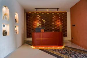 a lobby with a wooden desk in front of a wall at Soocha Villas in Yogyakarta