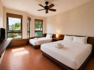 a bedroom with two beds and a ceiling fan at Camly the Boutique in Da Lat