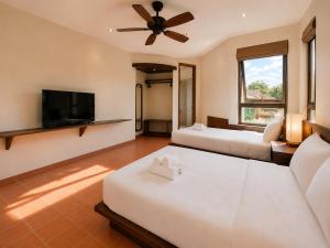 a living room with two beds and a flat screen tv at Camly the Boutique in Da Lat