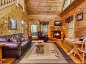a living room with a couch and a fireplace at Naughty Pines in Pigeon Forge