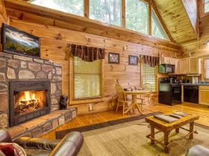 a living room with a fireplace in a log cabin at Naughty Pines in Pigeon Forge