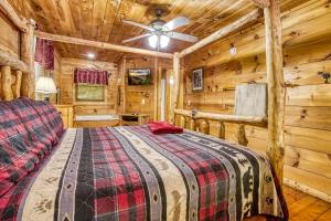 a log cabin bedroom with a bed and a ceiling fan at Naughty Pines in Pigeon Forge