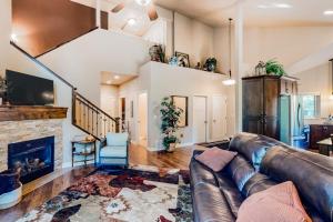 a living room with a leather couch and a fireplace at Cedar Point Hideaway in Columbia Falls