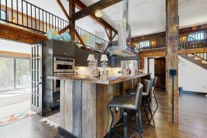 a kitchen with a large wooden counter with stools at Red Barn & Blueberries in Wells