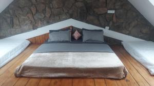 a large bed in a room with a stone wall at Captain's Cabin in Masinagudi
