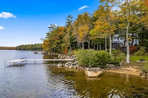 a house on the shore of a lake with a dock at Thompson Lake Estate in Poland