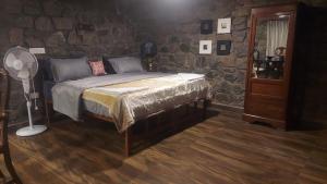a bedroom with a bed and a stone wall at Captain's Cabin in Masinagudi +4 photos