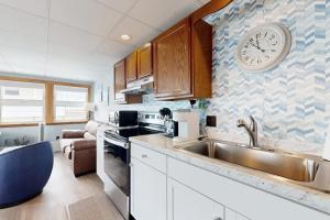 a kitchen with a sink and a clock on the wall at Shimmering Seaview in York