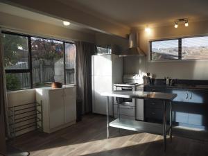 a kitchen with a white refrigerator and a table at Private Flat in Bridge Hill in Alexandra