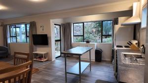 a kitchen and living room with a table and some windows at Private Flat in Bridge Hill in Alexandra