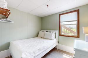 a small bedroom with a white bed and a window at Seafoam Dreams in York
