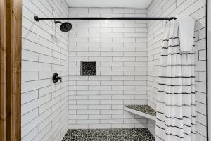 a white tiled shower with a bench in a bathroom at La Tierra Lodge in Lakeside +82 photos