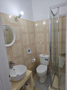 a bathroom with a toilet and a sink and a shower at Tony's Rooms in Alinda +84 photos
