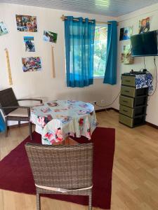 a room with a table and chairs and a television at Rurutu Randy in Rurutu