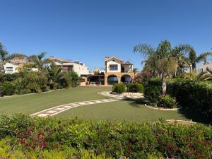 a large yard with a house in the background at Emerald Seafront Residence in Ayia Napa