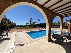 an archway over a swimming pool in a house at Emerald Seafront Residence in Ayia Napa