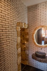 a bathroom with a brick wall with a sink at Two Sisters Villa with Pool - Sire in Tanjung