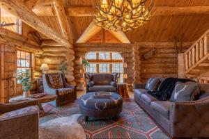a living room in a log cabin with a chandelier at Buffalo Creek Lodge in West Jefferson