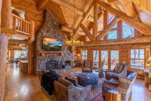 a living room with a fireplace and a stone wall at Buffalo Creek Lodge in West Jefferson